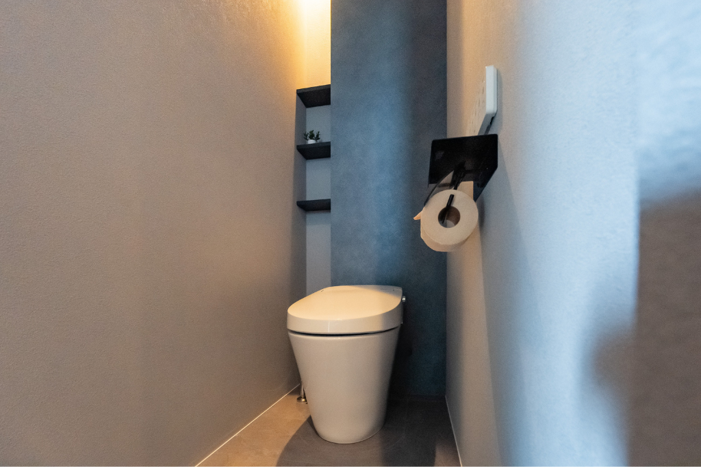 間接照明を使い、塗り壁のような陰影と奥行きを演出しているトイレの壁