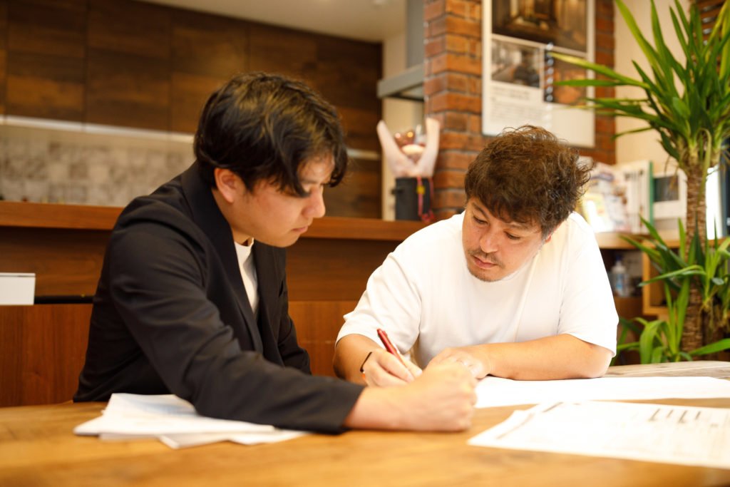 お客様と図面を見ながら宇治の街並みに合わせた提案をするスタッフ